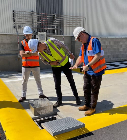Engineers inspecting Fox Enviro stormwater diversion valve at commercial site